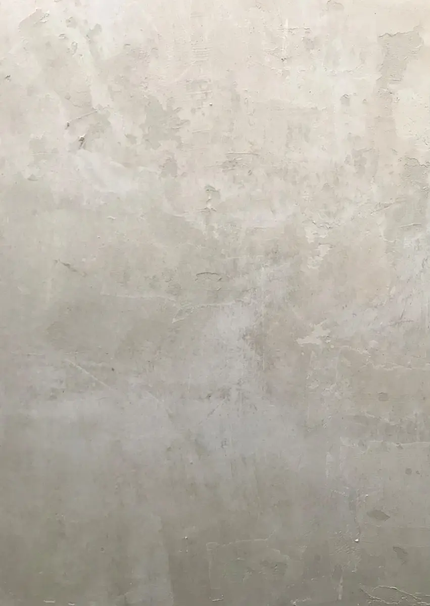 a man in a suit and tie standing in front of a wall